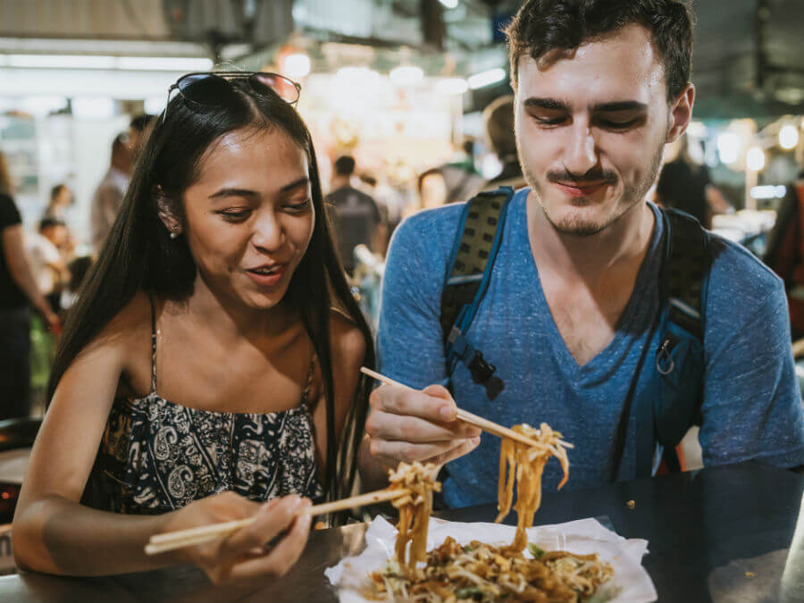 Couple eating street food in Asia