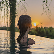 Woman looking at sunset in pool