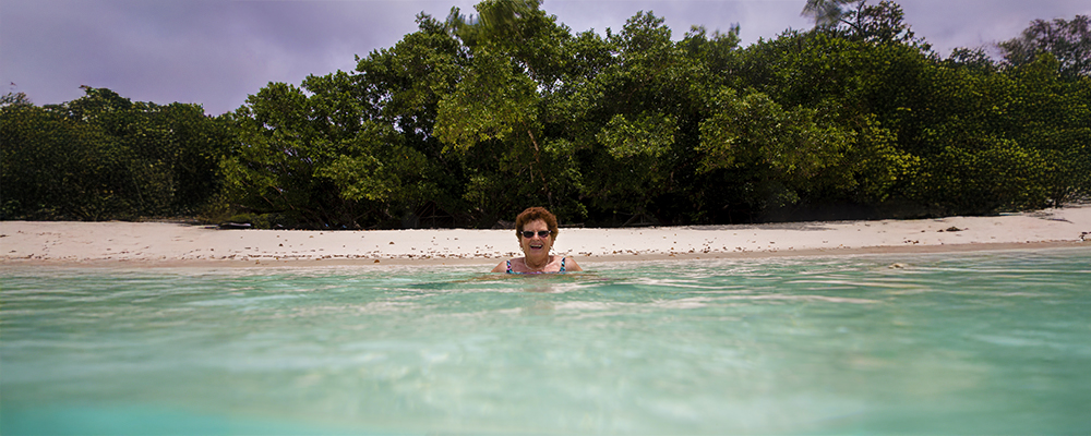 Woman in the ocean with beach in background