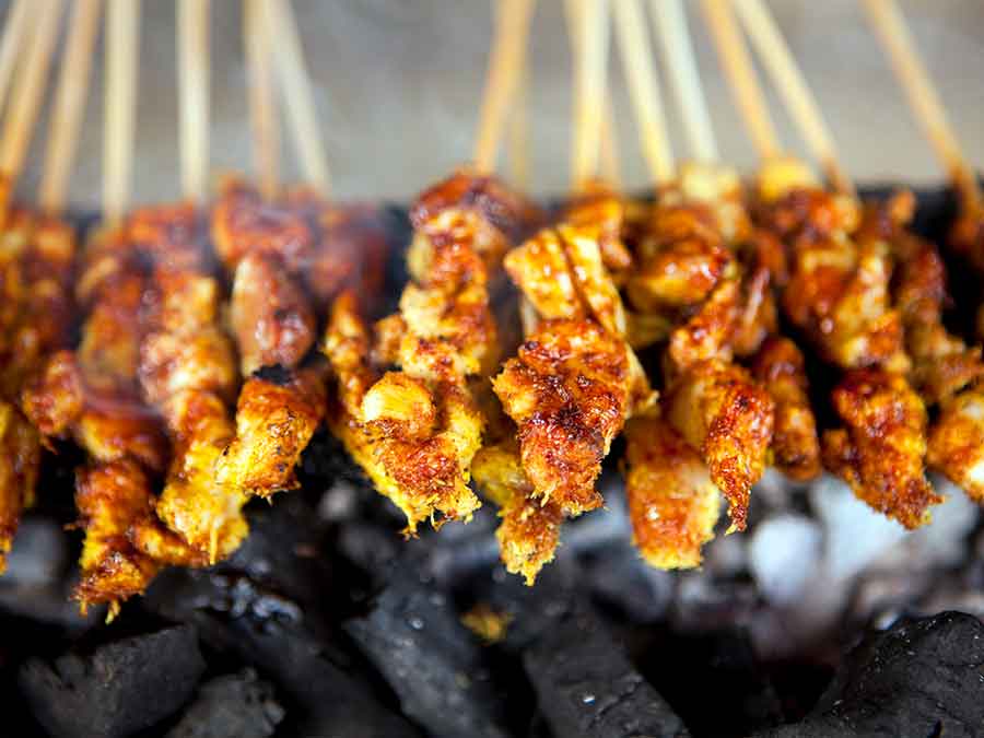 skewers being cooked over an open fire