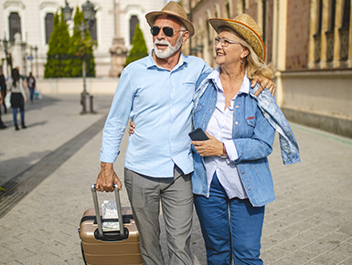 Senior couple walking with suitcase