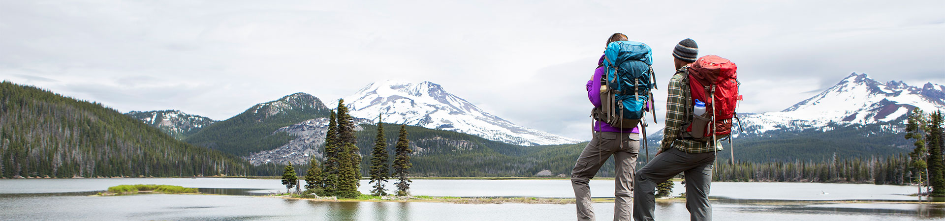 Two hikers looking over a lake.