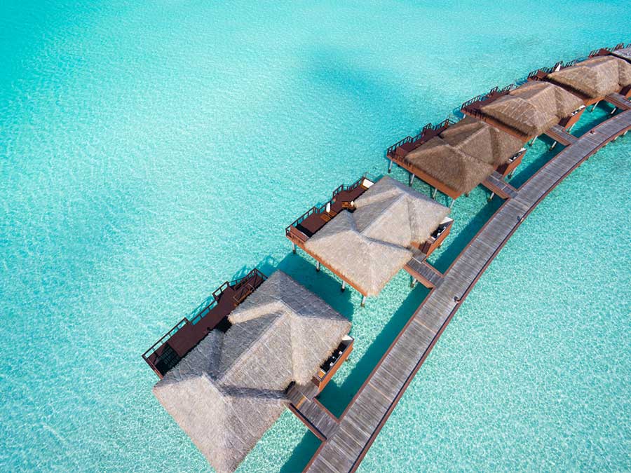 close aerial view of luxury overwater villas in tropical lagoon