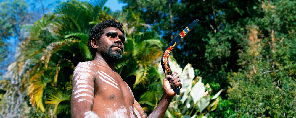 Aboriginal Australian standing in front of trees