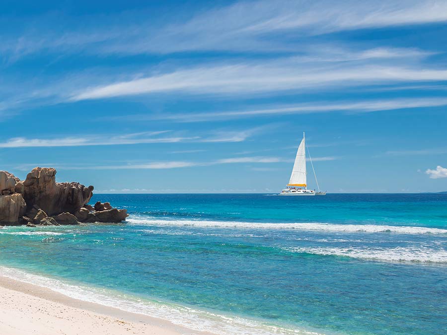 View of the beach with sailboat on the background
