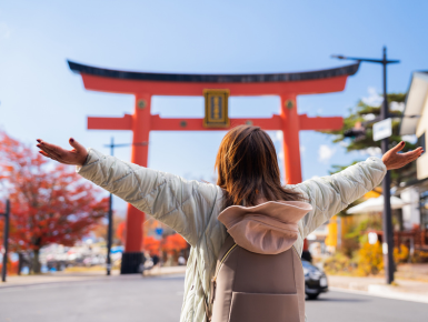 Woman with hands out in front of shrine