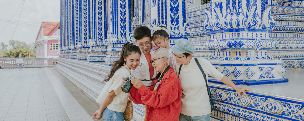 Family of tourists at temple review photo they've taken