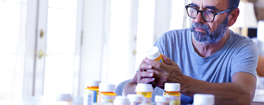 Man reading label of pill bottle